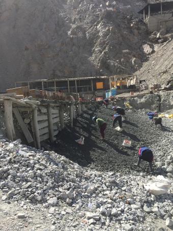 Workers at a small mine in Secocha, Peru pick through waste rock as they look for ore-rich pieces. Photo by Paul Santi