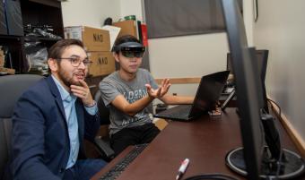 Assistant Professor Tom Williams working on a computer with grad student Nhan Tran