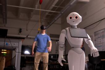 Student works with a humanoid robot in Xiaoli Zhang's lab