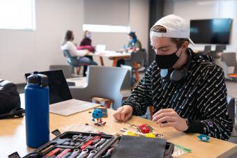 Masked student works on project in the new McNeil Hall