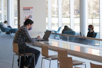 Student works on computer in CoorsTek atrium