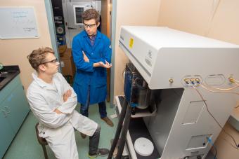 Mike McGuirk works in the lab with a graduate student