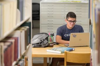 Male student works on computer in library