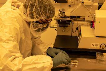 Graduate student Matt Tennery prepares a silicon sample for photolithography in the clean room on campus."