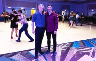 Griffin and friend posing on dance floor with lindyhoppers in background
