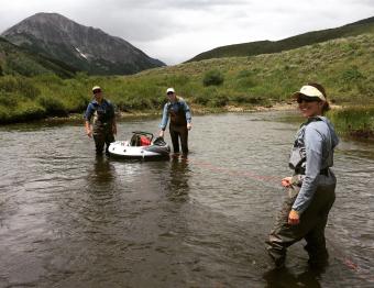 Kamini and 2 colleagues doing field work in river