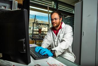 Researcher works on a computer in a mechanical engineering laboratory