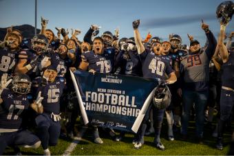 Mines football players celebrate with Championship Game banner