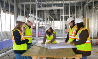Mines students look at blueprints inside Beck Venture Center construction site