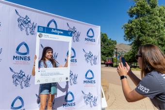 Student poses for photo at NEST booth on first day
