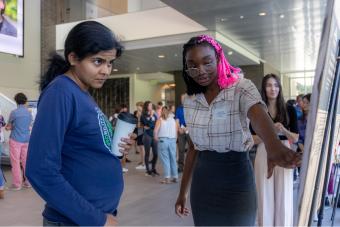 Praise Olusoji, quantitative biological engineering, shares her research with a student 