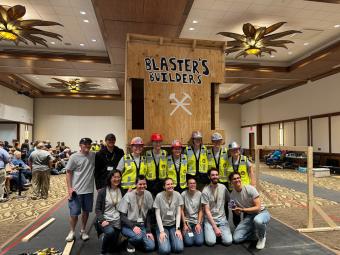 Mines team poses with completed building at competition