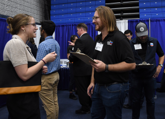 Geophysics and Geophysical Engineering student Duke Ozamah (second from right) speaking with Mike Casey, left, from Apache.