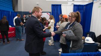 Male student shakes hands with female job recruiter