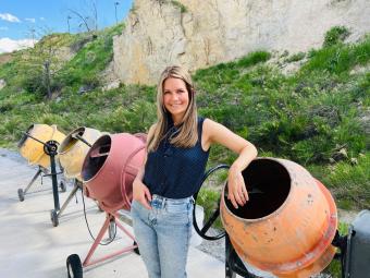 Lori Tunstall poses by concrete mixers