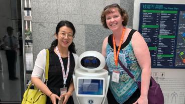 CUMT librarian Jie Bao shows Brianna Buljung a robot they use in their library.