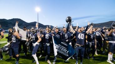 Mines football players celebrate with championship game banner