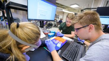 three students work together in biology class