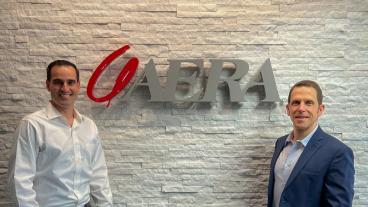 Nicholas Clausnitzer and Michael Dixon in front of Aera sign
