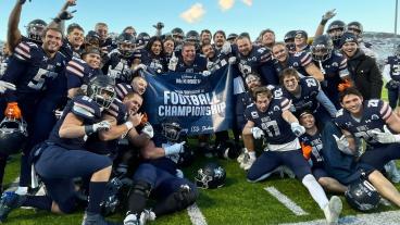 Football team poses with 2023 Road to National Championship banner