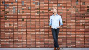 Portrait of Zack Bennett in front of brick wall