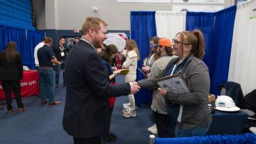 Male student shakes hands with female job recruiter