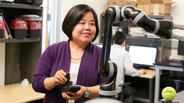 Xiaoli Zhang operates a robotic arm in a lab at Mines