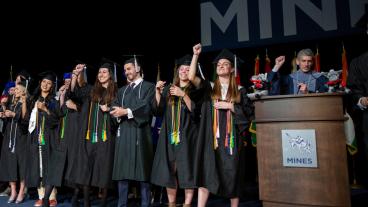Jennifer Kendall and her fellow student athletes lead the Mines fight song at commencement