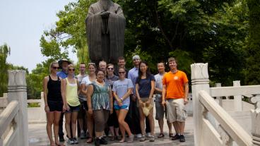 McBride Honors students pose in front of a statue of Confucius in Qufu, China.