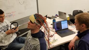 Students testing headpiece with infrared emitters and sensors