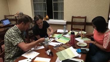 Mines students Jake Weems, Lindsay Hoylman and Vy Duong prepare for field work by painting and drawing items to assist in the interview process.