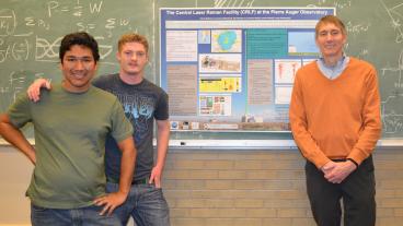 Applied physics graduate student Carlos Medina, engineering physics junior Steven Hackenburg and physics professor Dr. Lawrence Wiencke. The poster in the background shows the laser facility at the Pierre Auger Observatory used in this project.