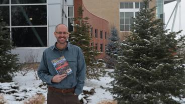 Kenneth Osgood, associate professor and director of the McBride Honors Program, holds his new book, “Winning While Losing: Civil Rights, the Conservative Movement and the Presidency from Nixon to Obama” on Mines campus. 