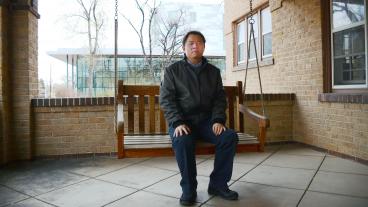 Rui Zhao sits on the swing on the front porch of Coolbaugh House at Mines