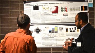 Mohammed A Duhailan explains his research to a fellow student during the CEER conference.
