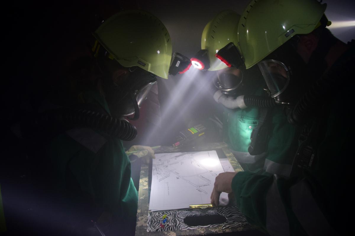 A team looks at a map to find and rescue a victim during the field competition at the Edgar Mine.