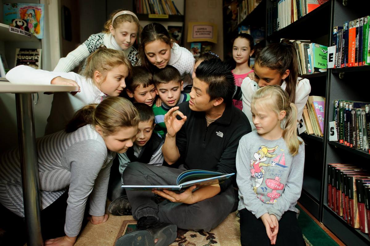 Peace Corps volunteer reads books to children in Moldova.